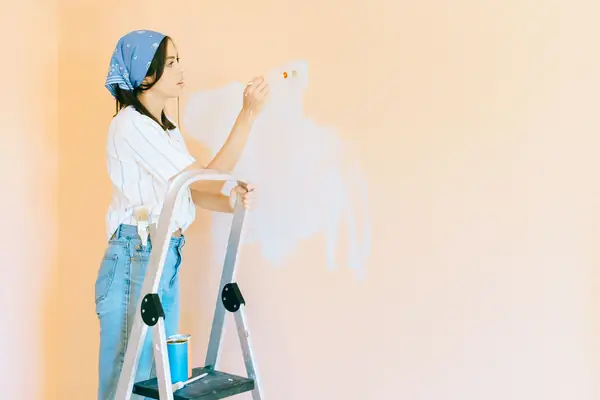 Interior painting in Reno: painter on a stepladder rolling a wall